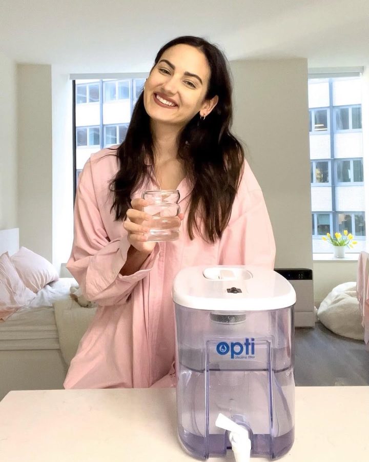 Opti customer holding a glass of filtered water